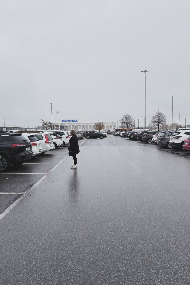 a photograph of a woman on a parking lot