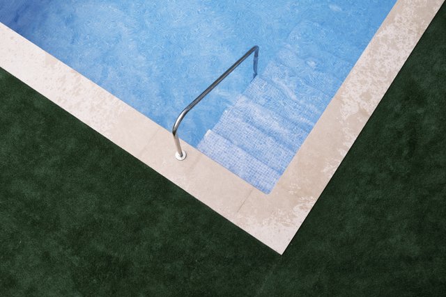a photograph of a pool with a metal railing and a metal handrail