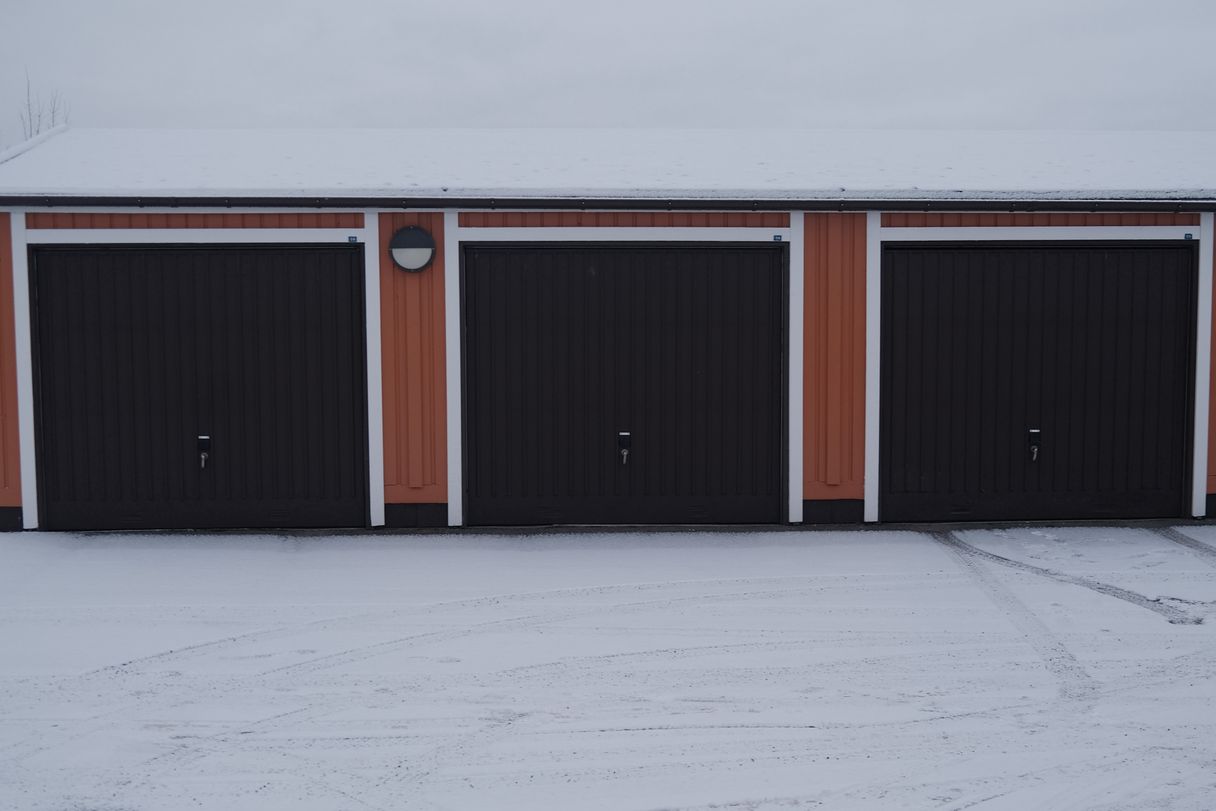 a photograph of a garage with a garage door and a fire hydrant