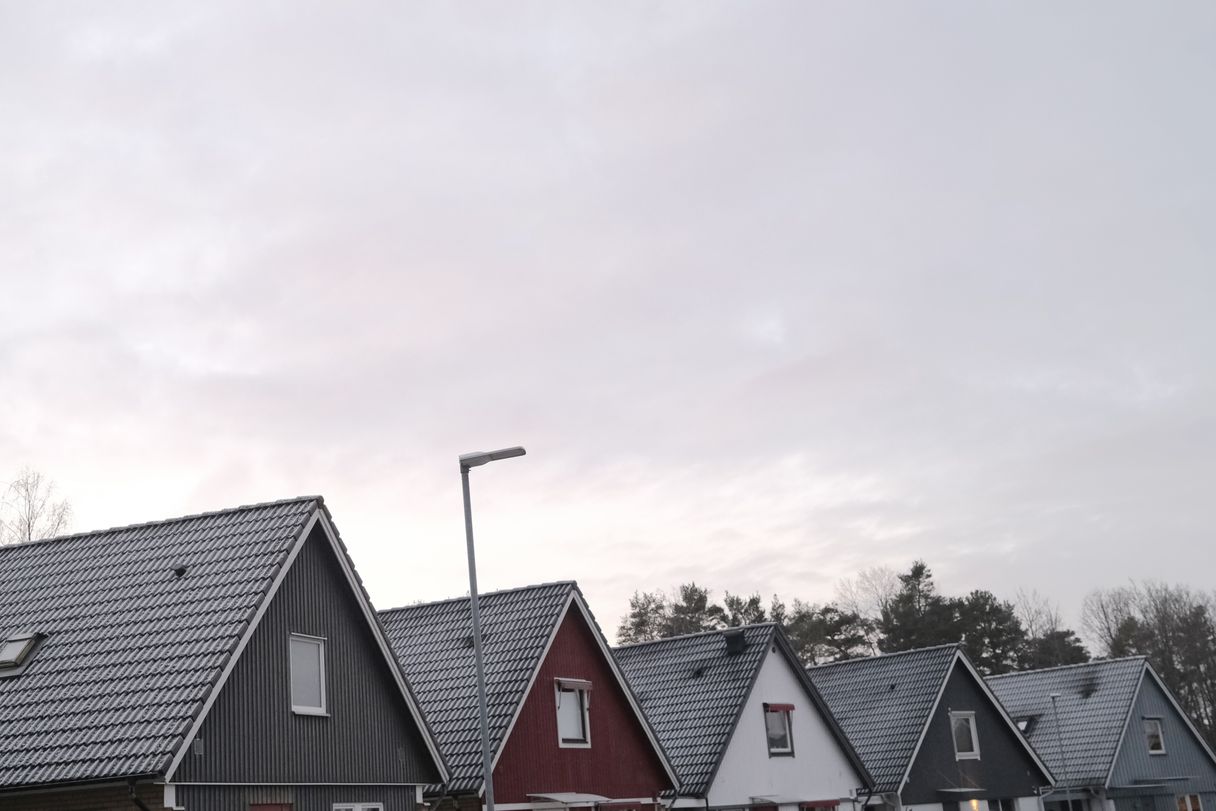 a photograph of a row of houses with a clock tower in the background