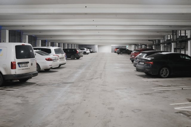 a photograph of a parking lot with several parked cars in it