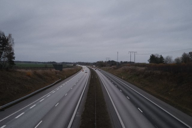 a photograph of a highway with cars driving down the road