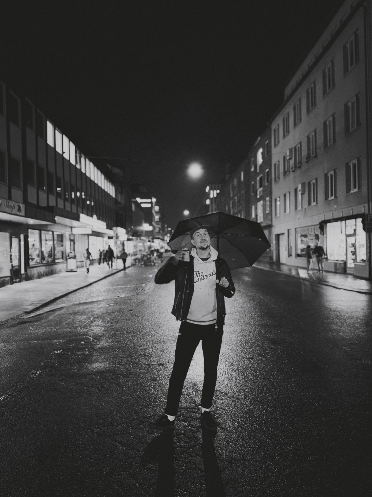 a photograph of a man holding an umbrella in the middle of a city street