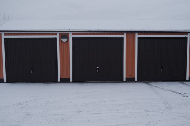 a photograph of a garage with a garage door and a fire hydrant