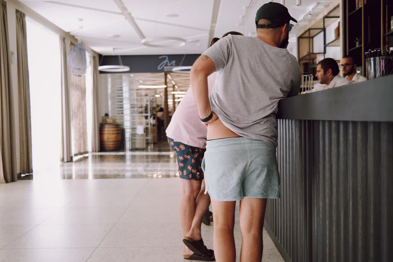People standing at a hotel reception counter in a bright hallway.