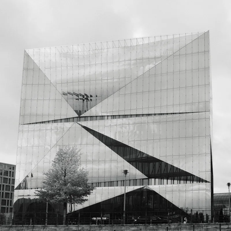 Large concrete building with diagonal concrete walls, cross-bracing, and an open entrance facade.